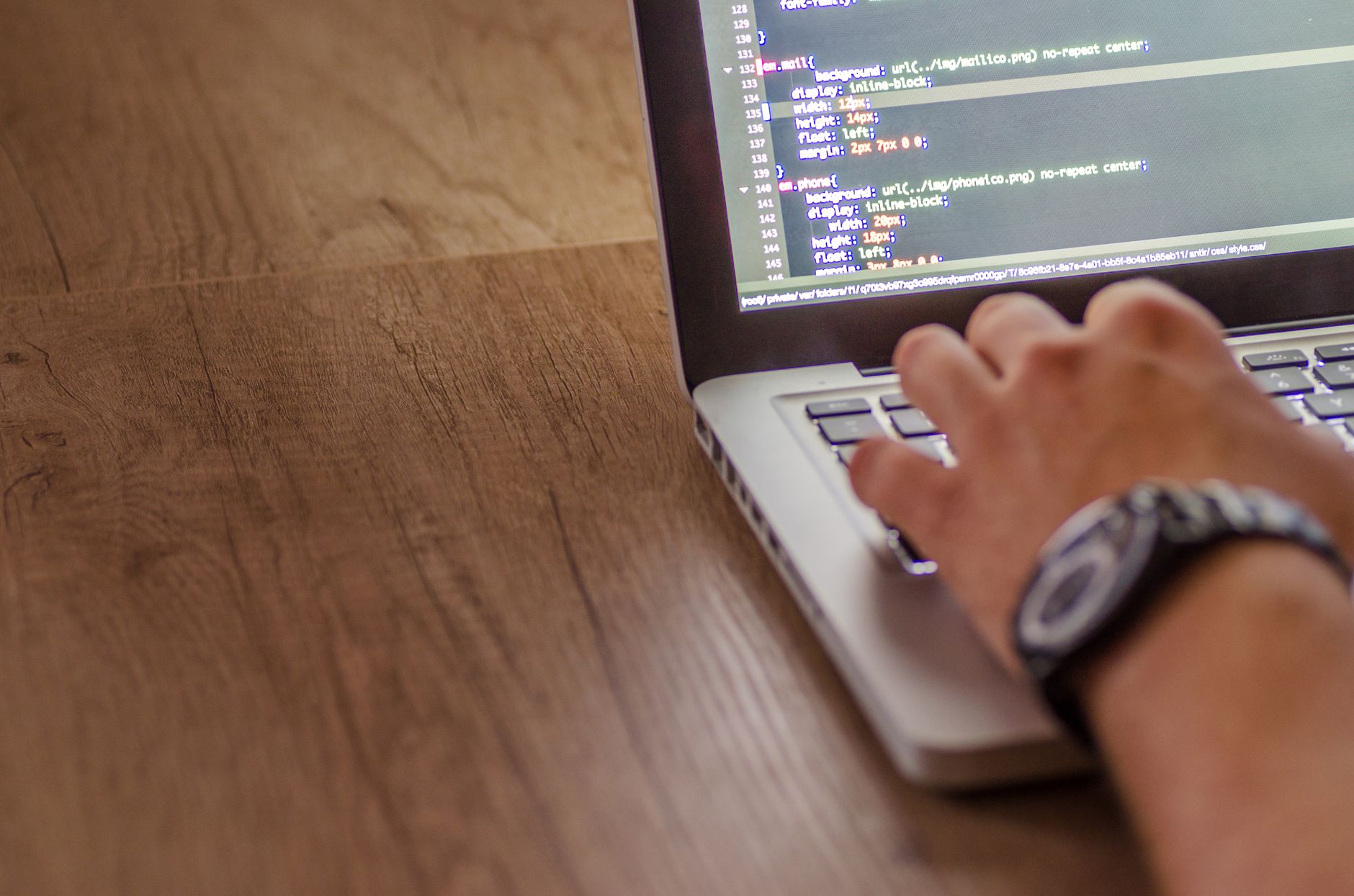 Developer reviewing code on a laptop with Jira and GitHub tabs open.
