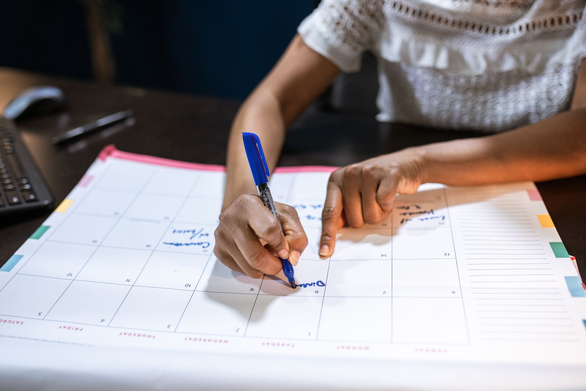 Persona asignando bloques de tiempo en un calendario para tareas críticas de varios clientes