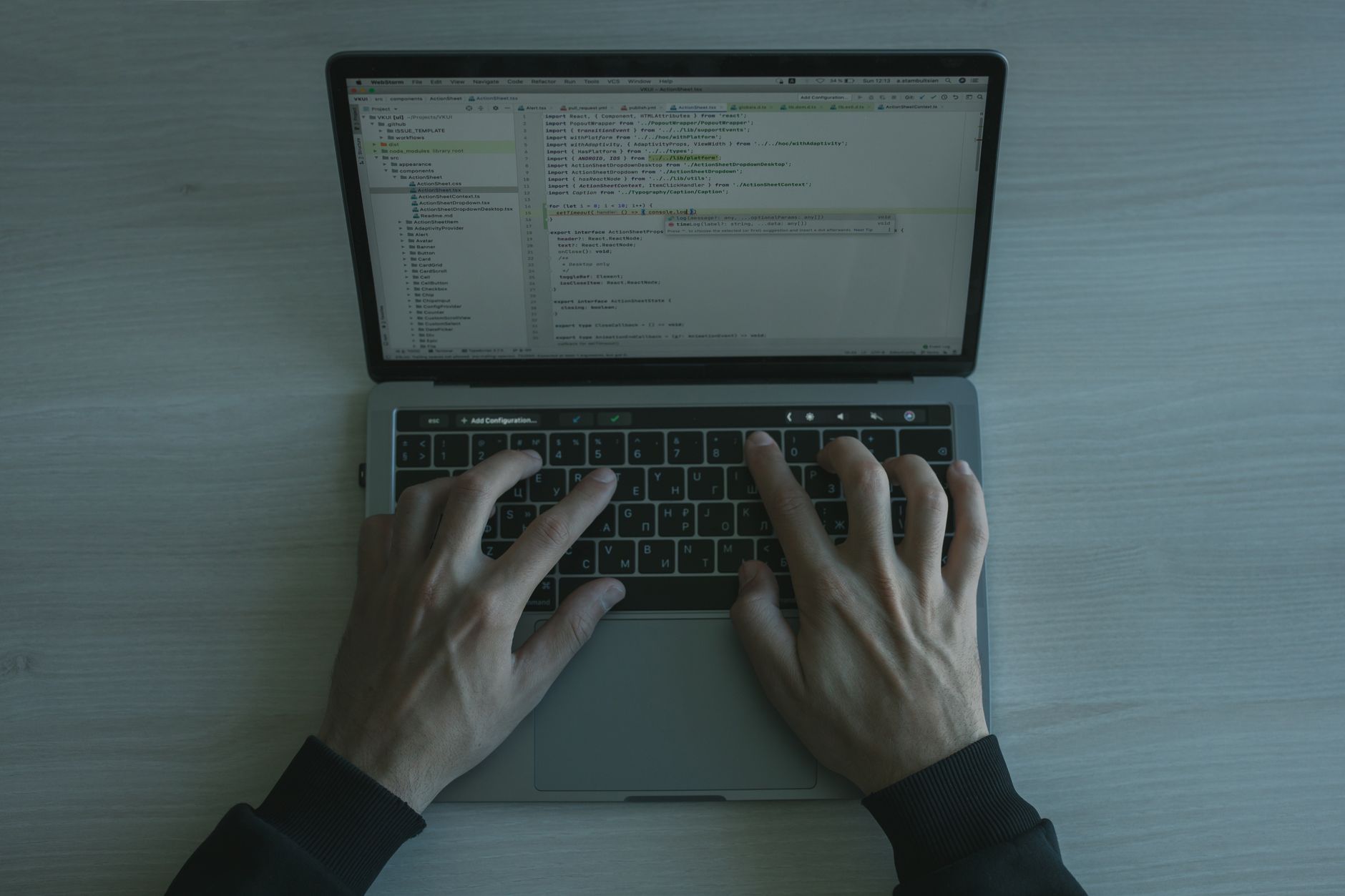 Developer reviewing GitHub issues on a laptop with Foco open in the background