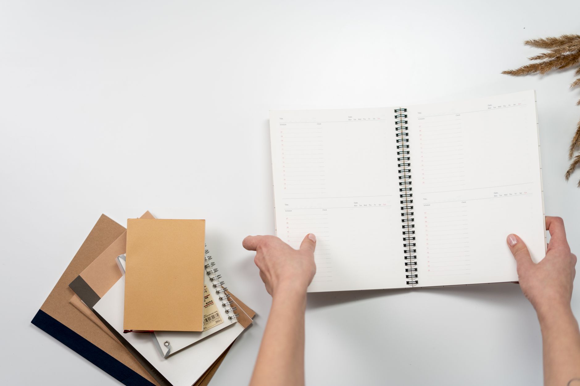 Freelancer planning time blocks in a notebook next to a laptop