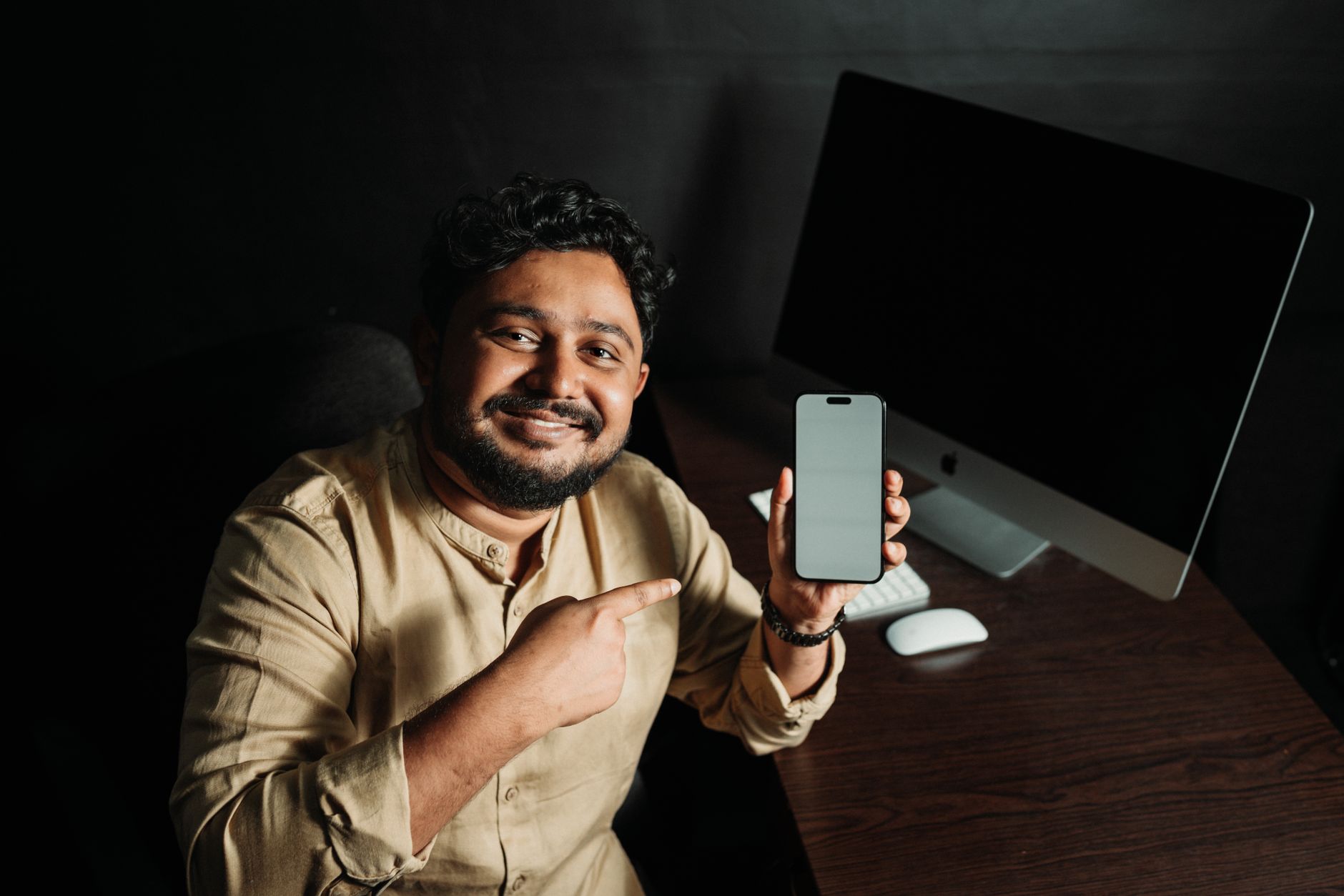 Person comparing app interfaces on mobile and desktop for task management.