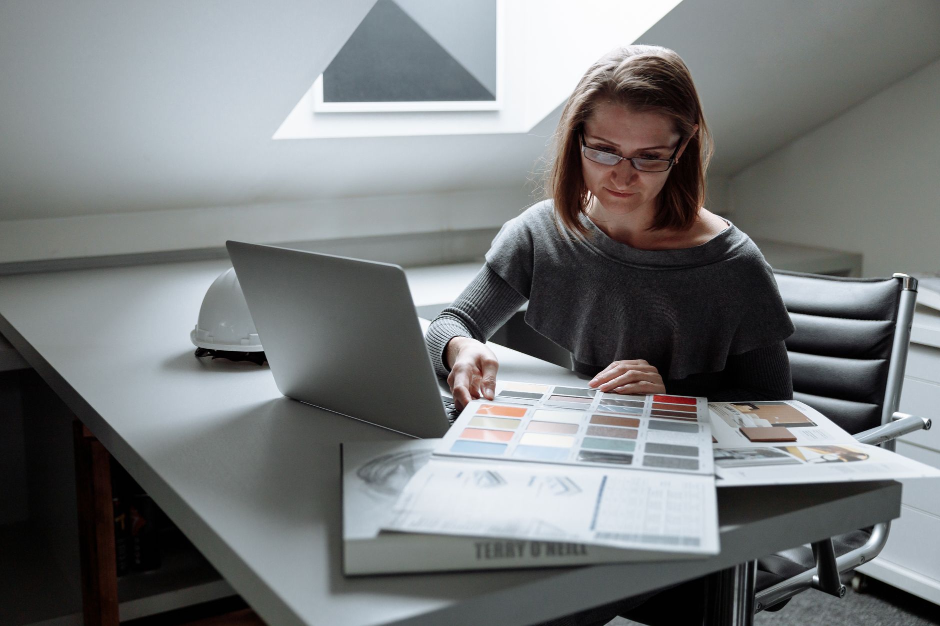 Designer working on multiple projects with time blocks on laptop