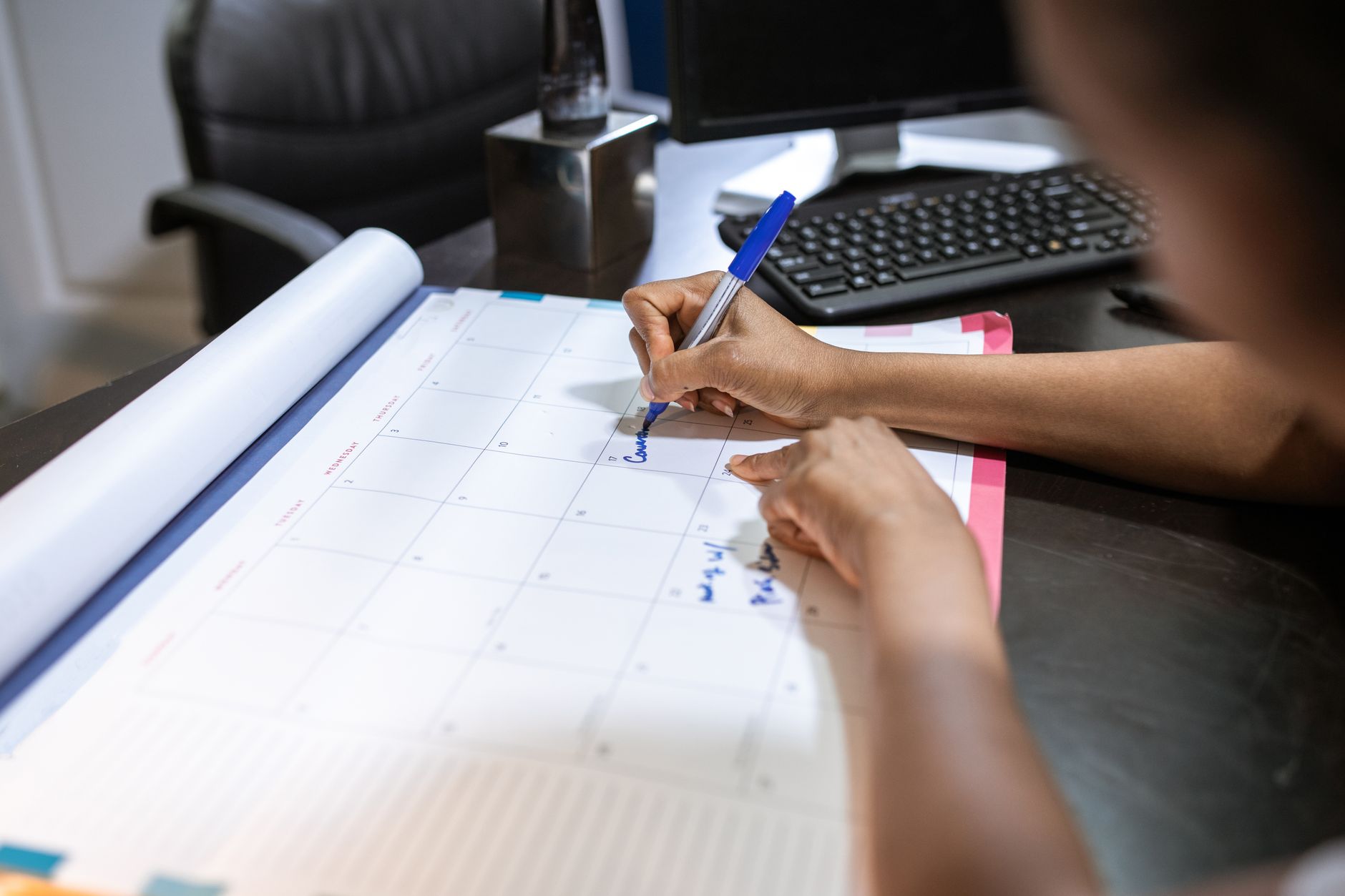 Designer reviewing tight deadlines on a calendar to manage multiple jobs