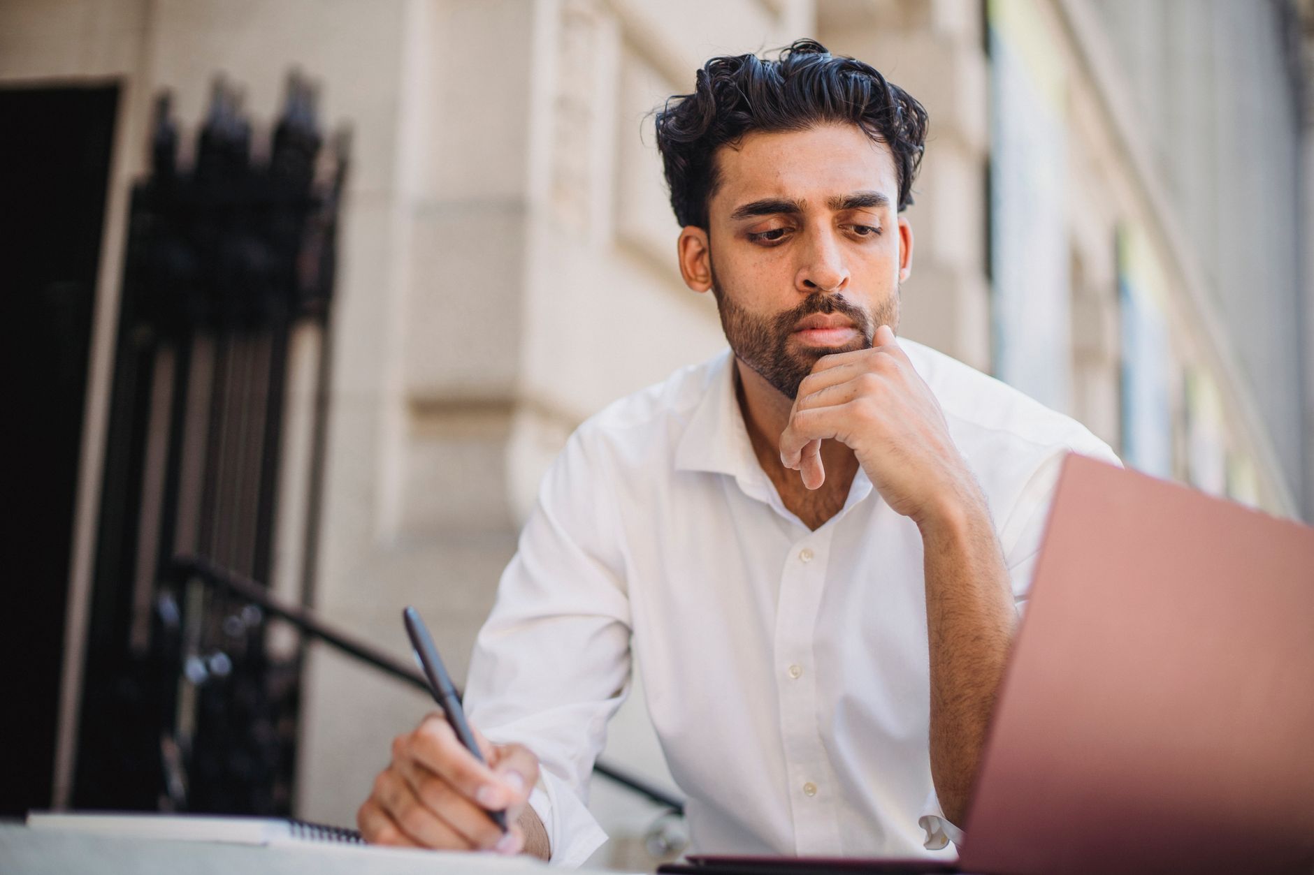 Freelancer reviewing pending tasks on laptop with sticky notes