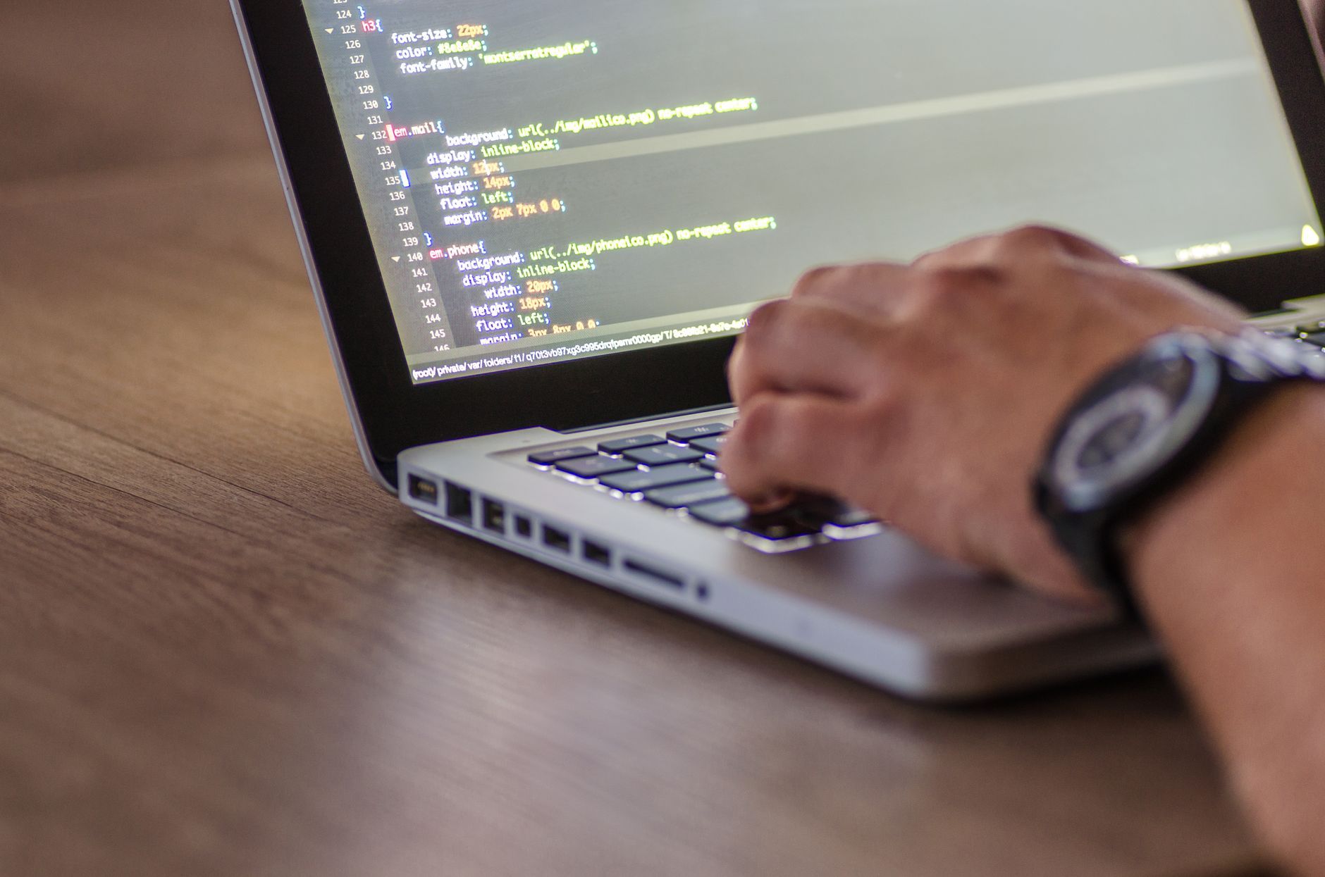 Developer coding on laptop with comments in the code